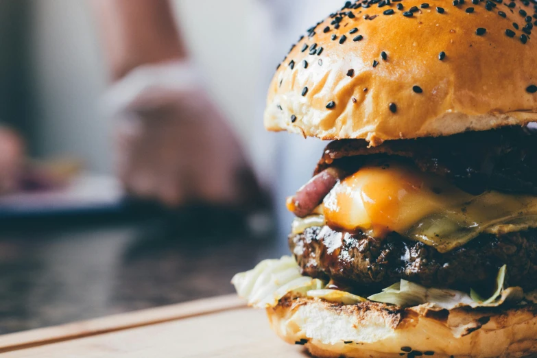 cheeseburger sitting on a board and a person walking down the street