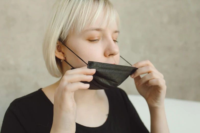 a blonde woman with closed eyes is covering her mouth