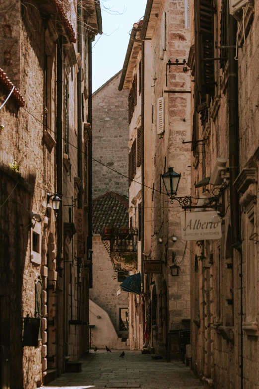 old buildings line an alleyway in a stone walled town