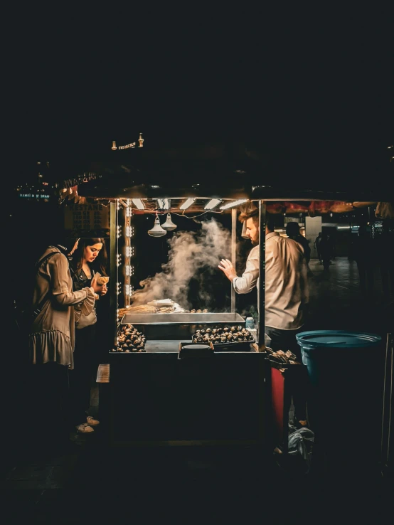 two people standing outside looking at food