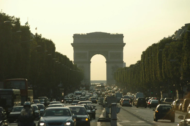 a group of cars drive down the road near the arc de trio peaks