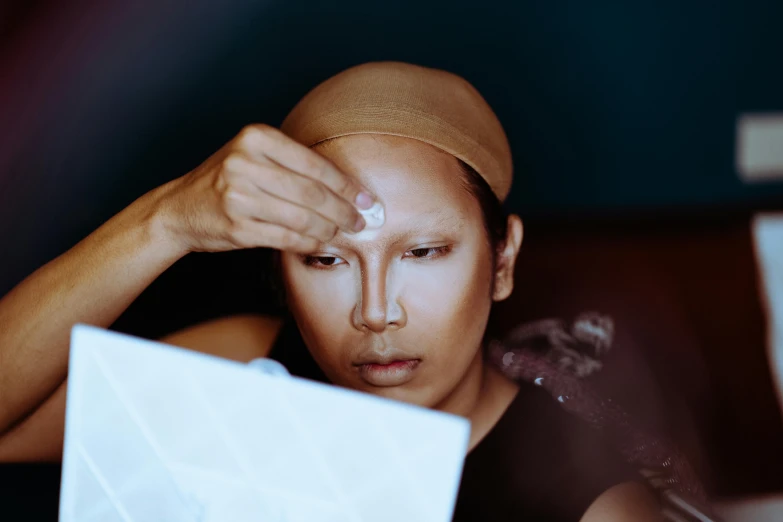 a person looking at a white object on a desk