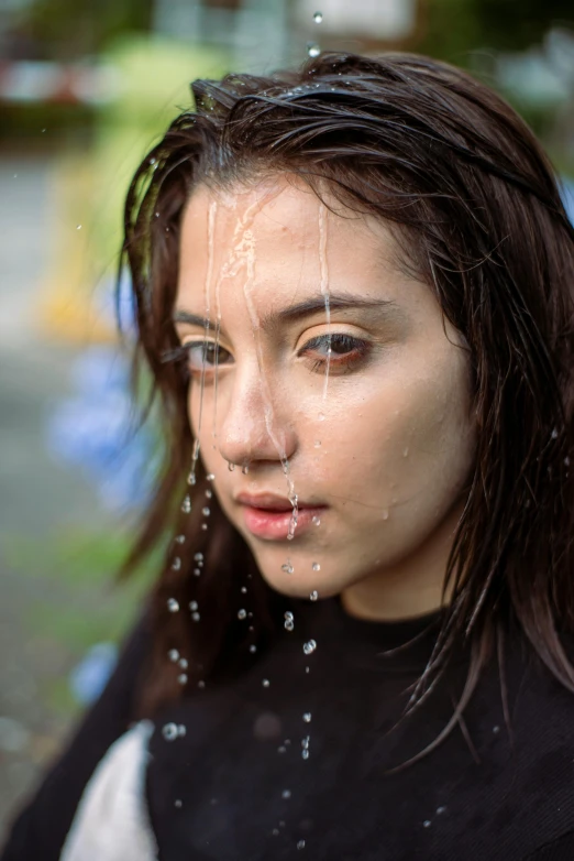 a young lady with her wet hair and eyes water drops from the top of her head