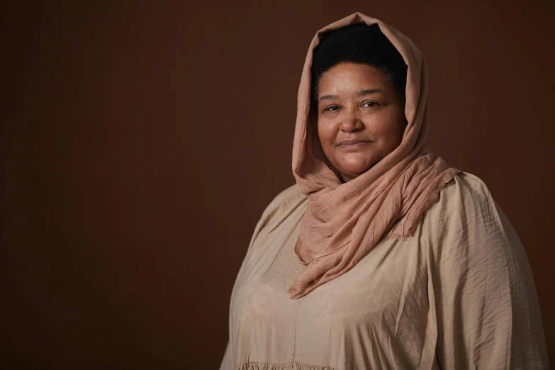 an asian woman wearing a shawl and smiling