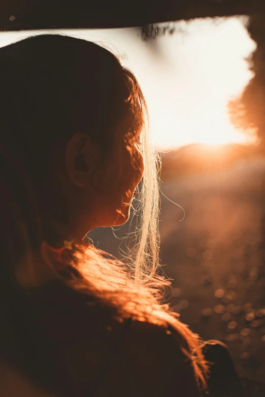 woman with long white hair staring at the sunset