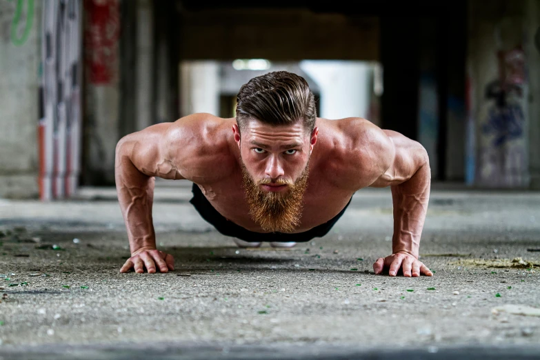 a man with beard and moustaches, is doing h up in the floor