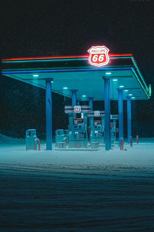 gas station lit up in the snow at night