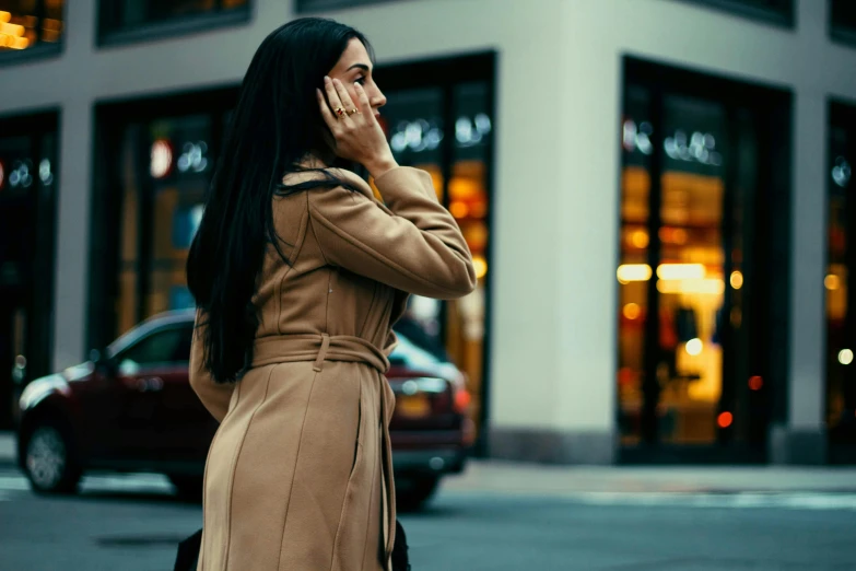 woman in a trench coat on the phone