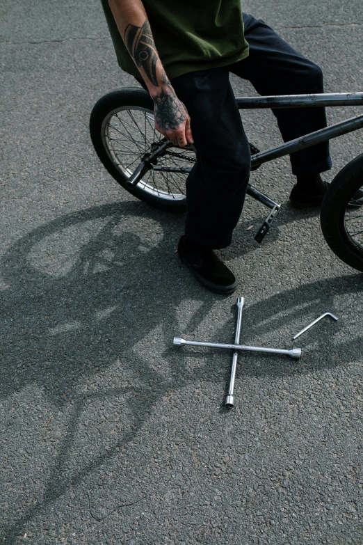 a man stands next to a broken bicycle