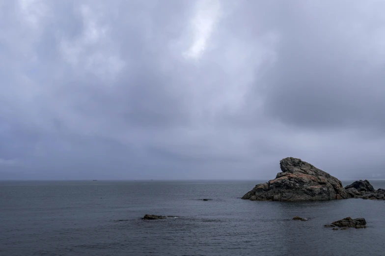 a person walking by some rocks in the water