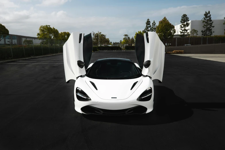 two white sport cars are parked on a black street