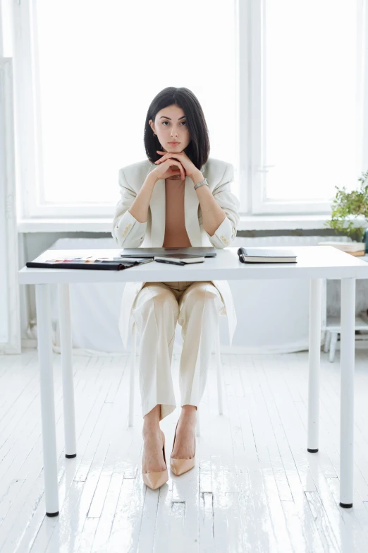 a woman sitting at a table while looking to her right