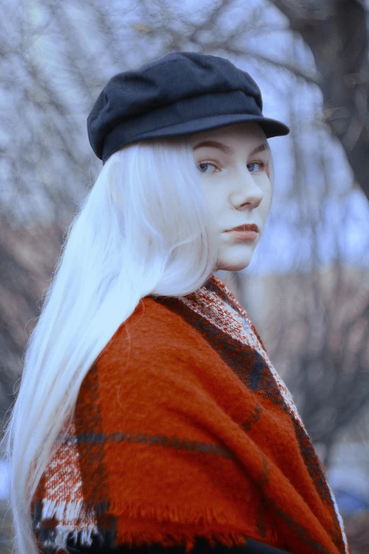 a woman in a hat and cape, posing for a po