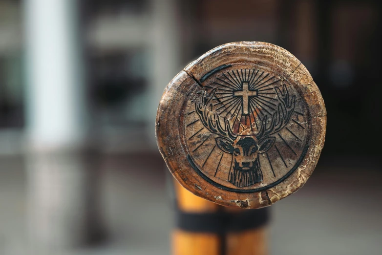 a wooden cross emblem sits on the back of a pole