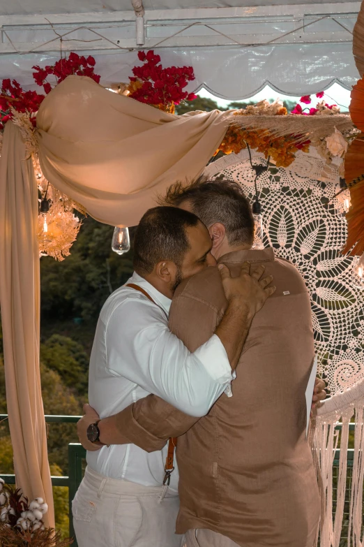 two men hug each other under the curtain