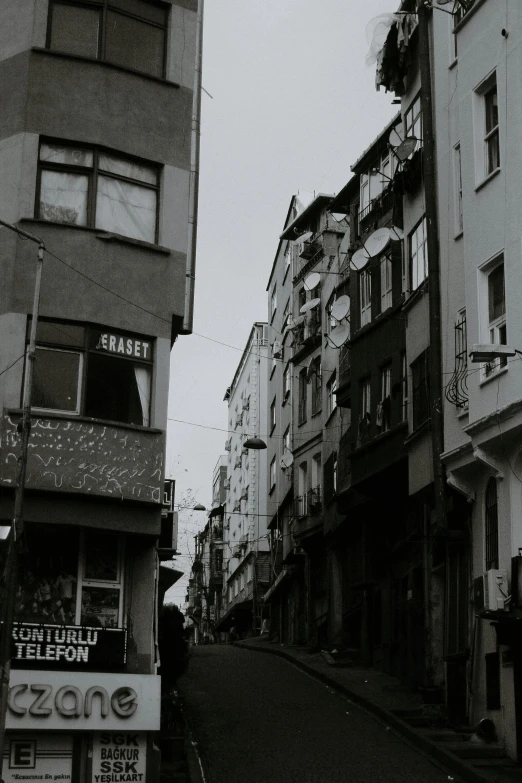 several buildings in a narrow urban street in the rain