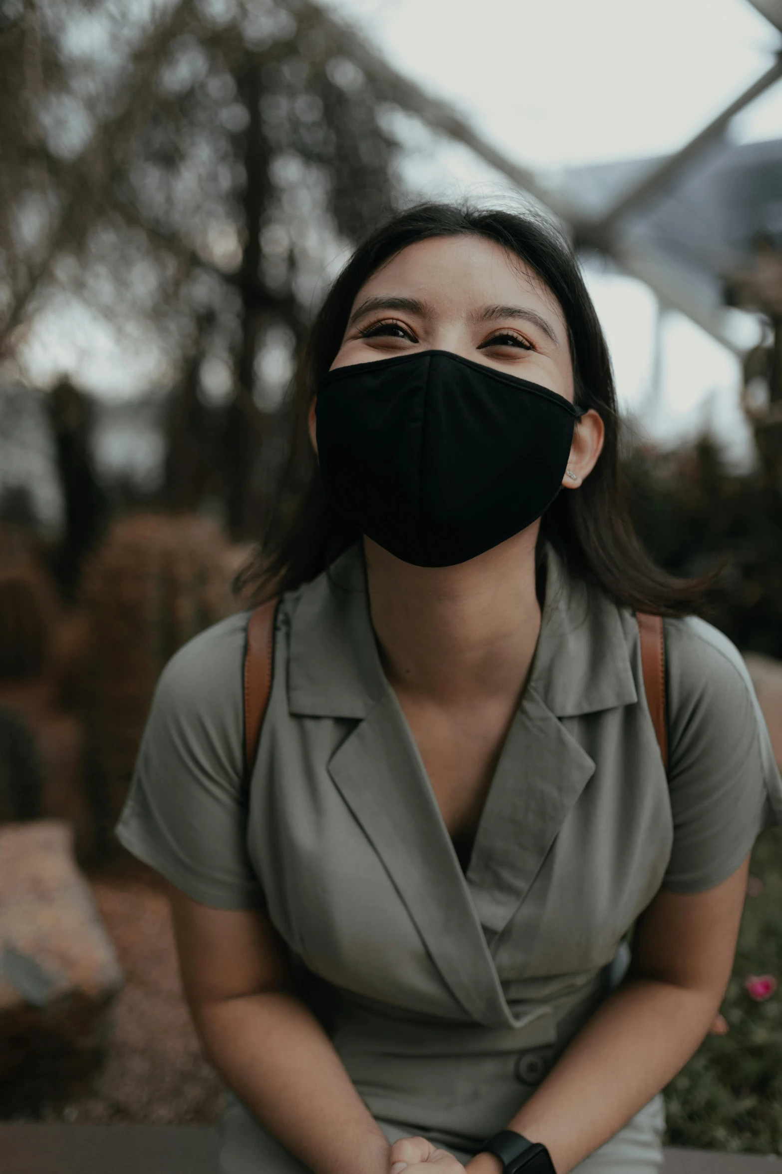 woman wearing a black mask with straps posing in the park