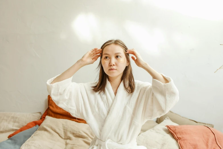 a woman sitting on top of a bed under a tree