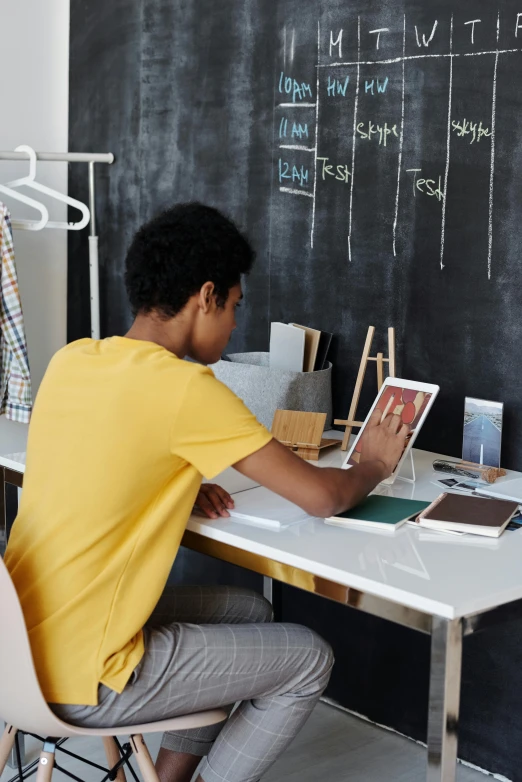 a man at a table drawing on a chalkboard