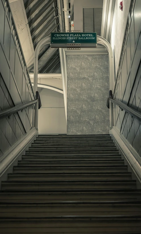 the steps down to a building are next to the green sign