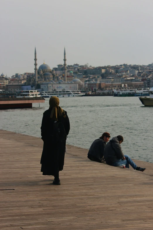 a group of people sitting on the shore near water