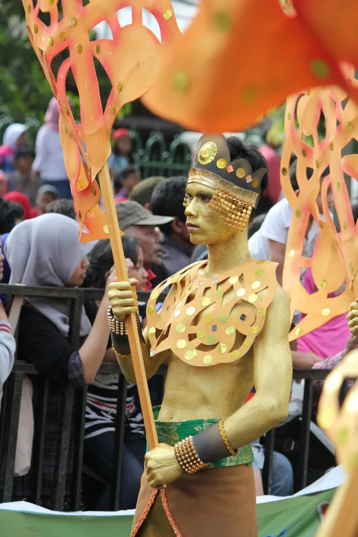 a man dressed as a dancer holding an orange flag