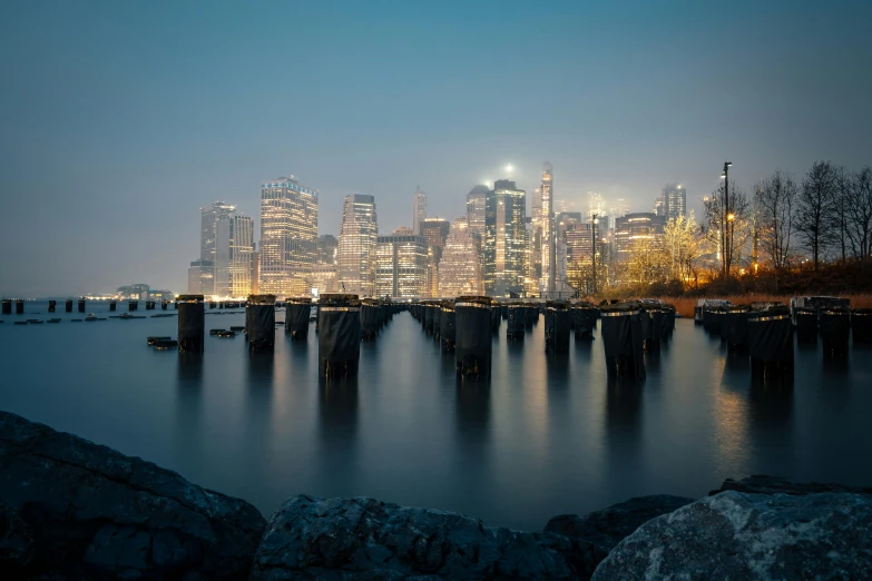 city skyline at night over water and a large river