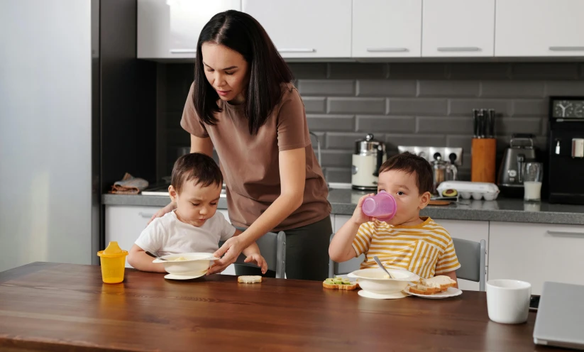 the woman is pouring milk to her sons