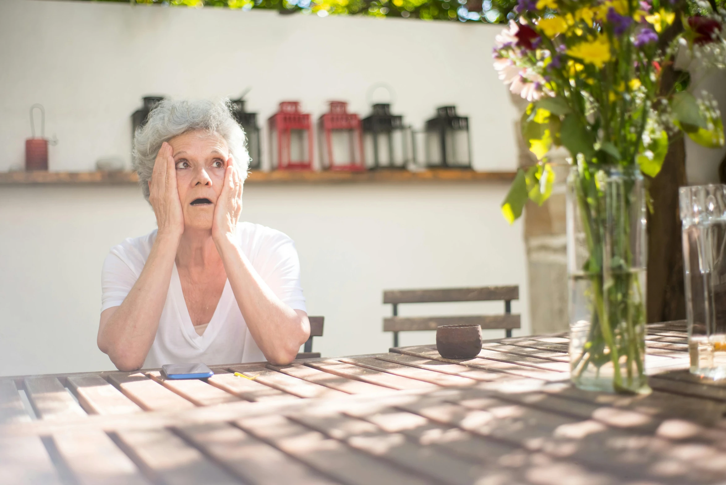 a woman sitting at a table with flowers in front of her