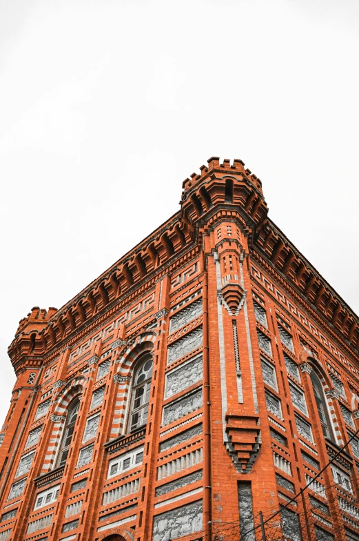 a red brick building stands in front of a blue cloudy sky