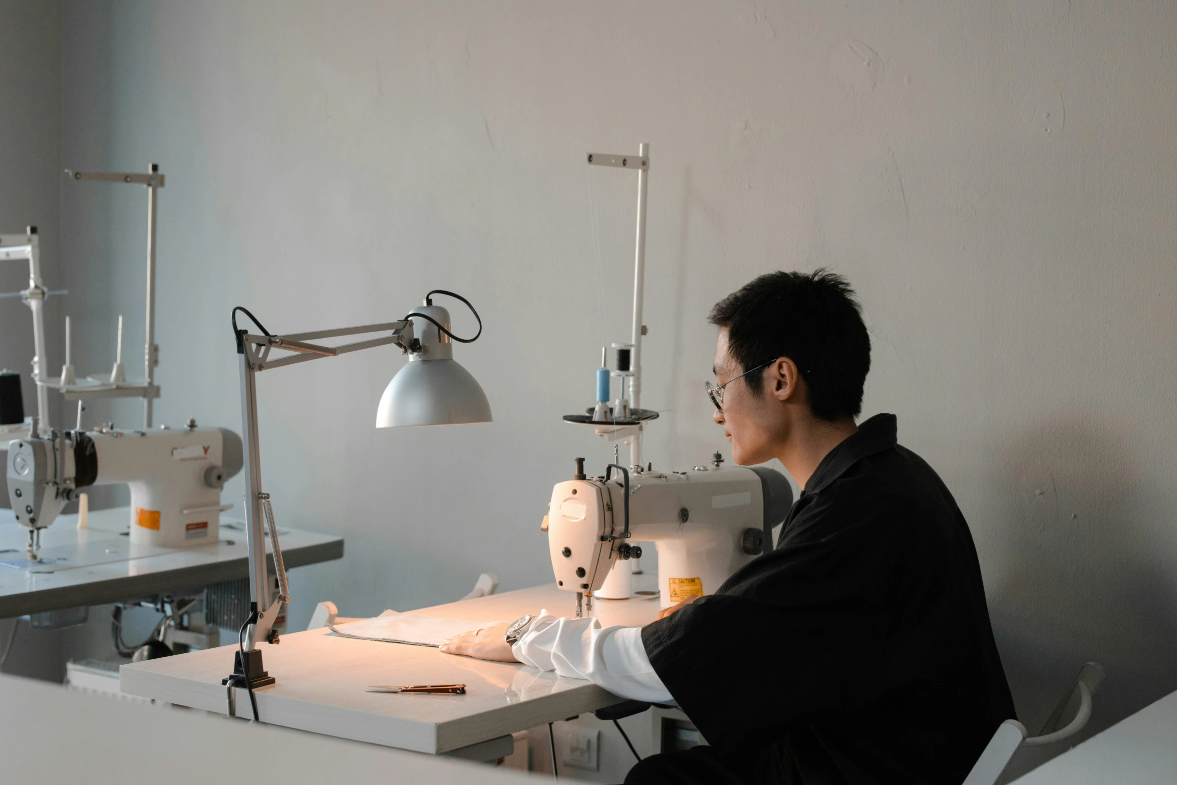 a man in a sewing studio looks at a machine