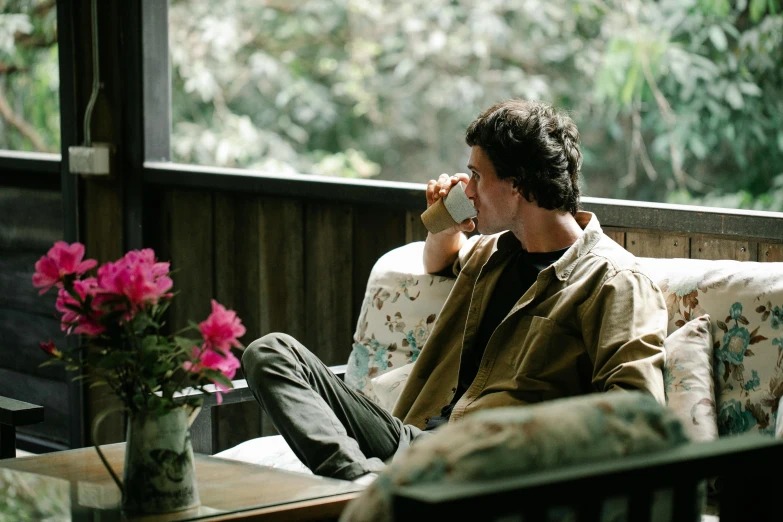 a man that is sitting down and drinking