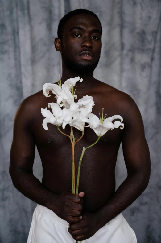 a man standing in front of a curtain with an arrangement of flowers attached to his chest