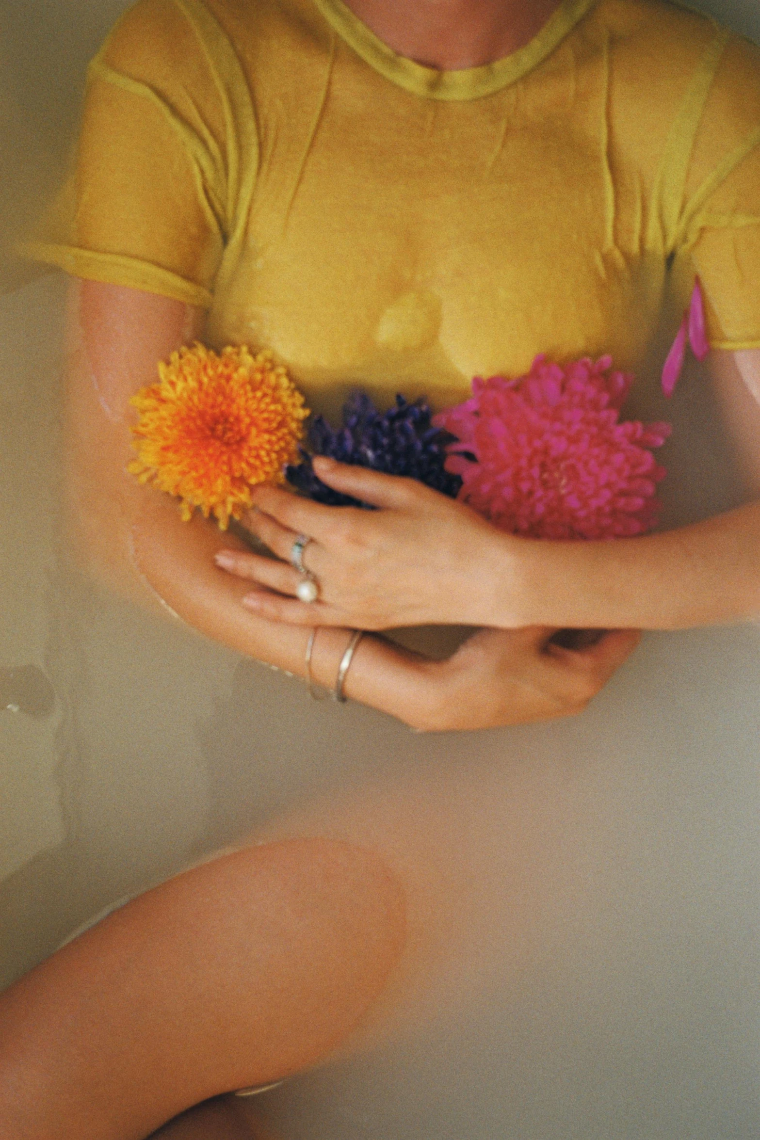 a woman in a yellow shirt with her hands on two pompoms