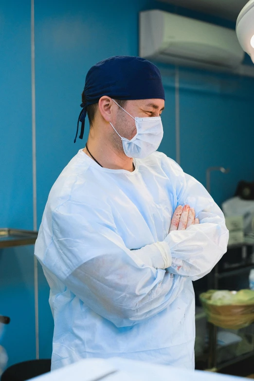 a male surgeon wearing scrubs and a white mask