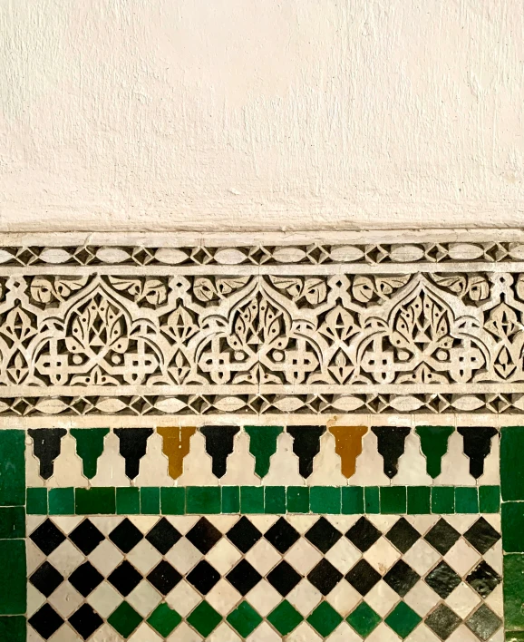 close up of a green, white and gold tiled wall