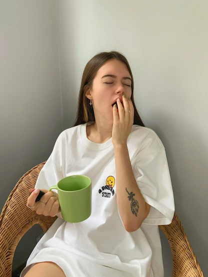 a woman with a green mug while sitting down