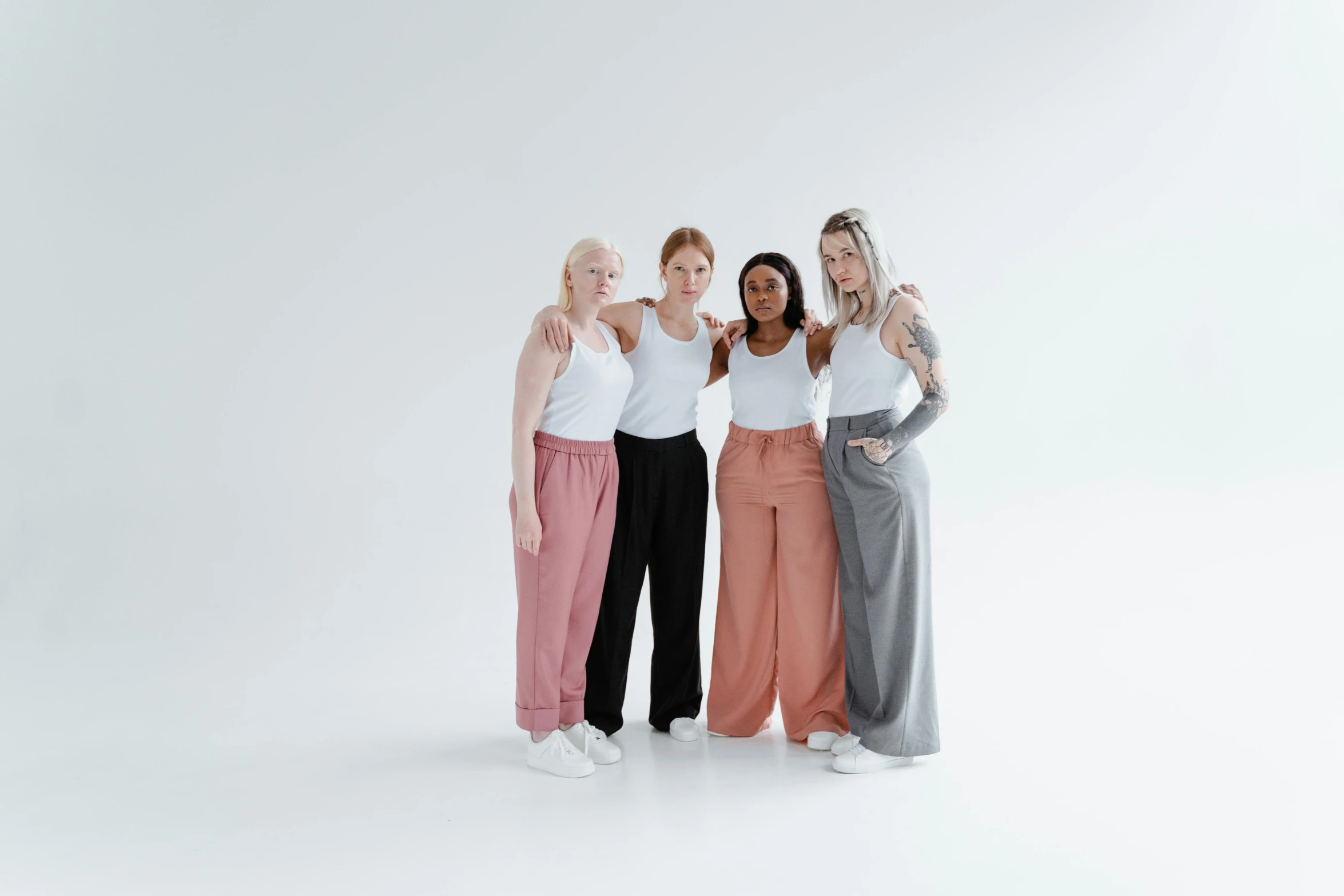 three women in pant suits posing for a studio po