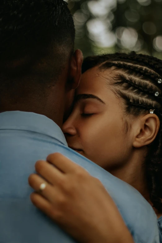 black woman hugging a black man who is kissing her