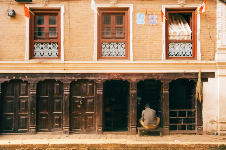 a man sits on the doorstep of a building