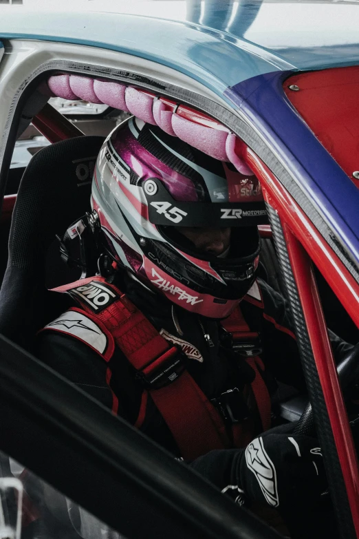 a person with a red uniform sitting inside of a car