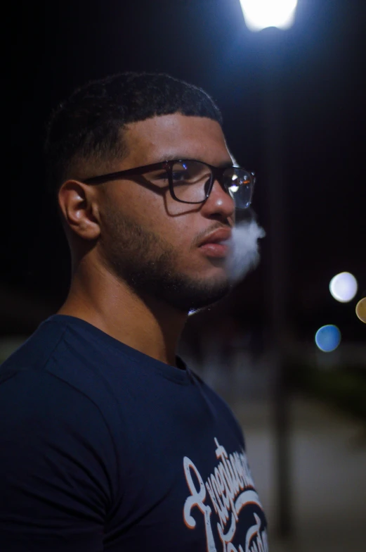 man wearing eyeglasses and a dark shirt staring at soing