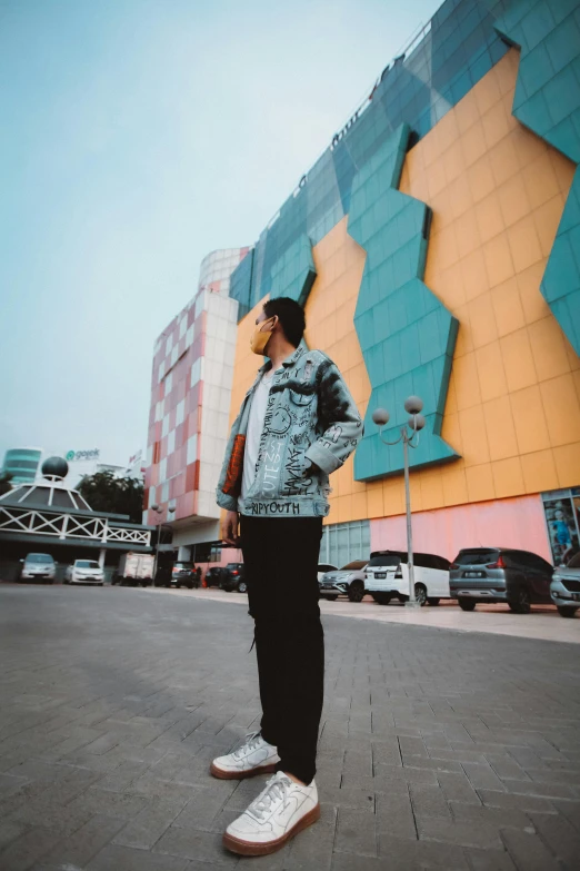 man in blue jacket standing in front of buildings