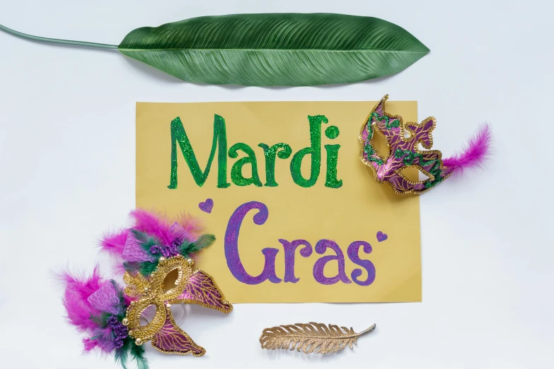 the mardi gras sign has pink and green feathers