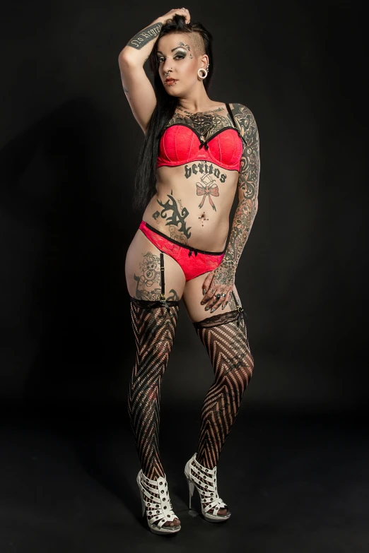 the young woman has tattoos and is wearing a fishnet