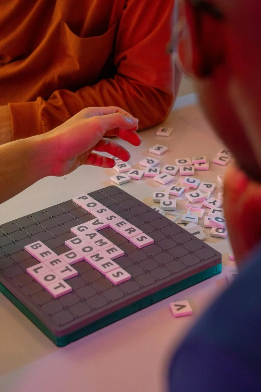 two people are working with letters on a laptop