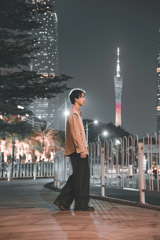 a man stands on a bridge in front of a cityscape