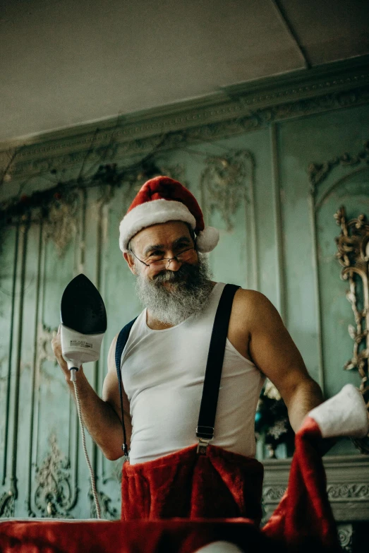 an old man with long hair wearing a santa claus hat holding a microphone