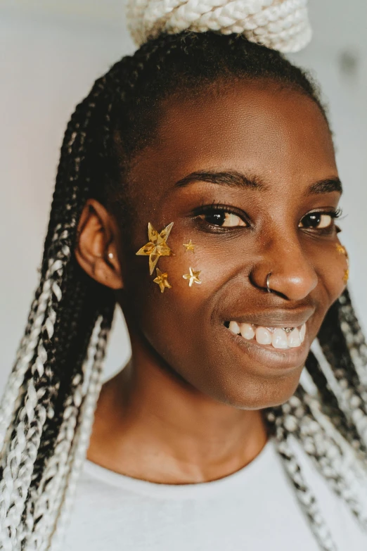 an african american girl wearing a golden face tattoo