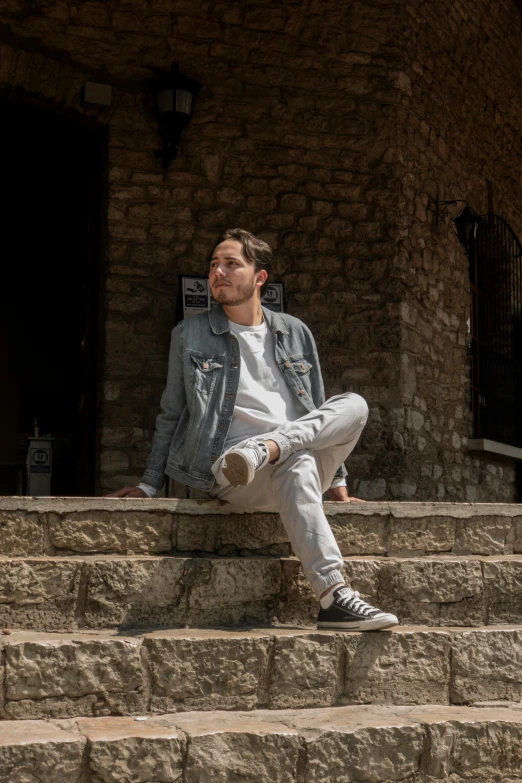 a man sitting down on stairs outside of an old building